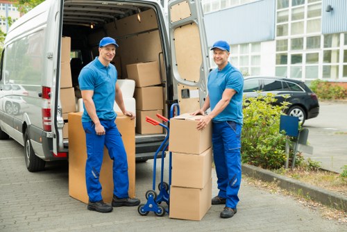 Flat removal team carrying boxes in a Crystal Palace apartment building